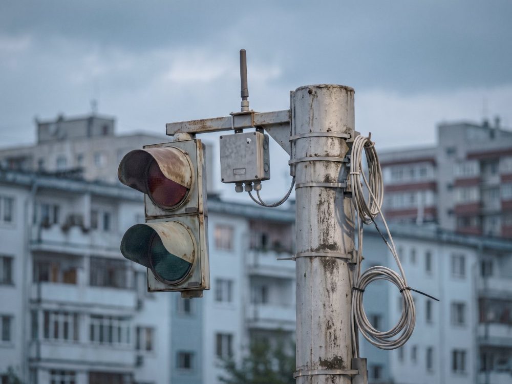 A street pole carrying a traffic signal and a sensor unit